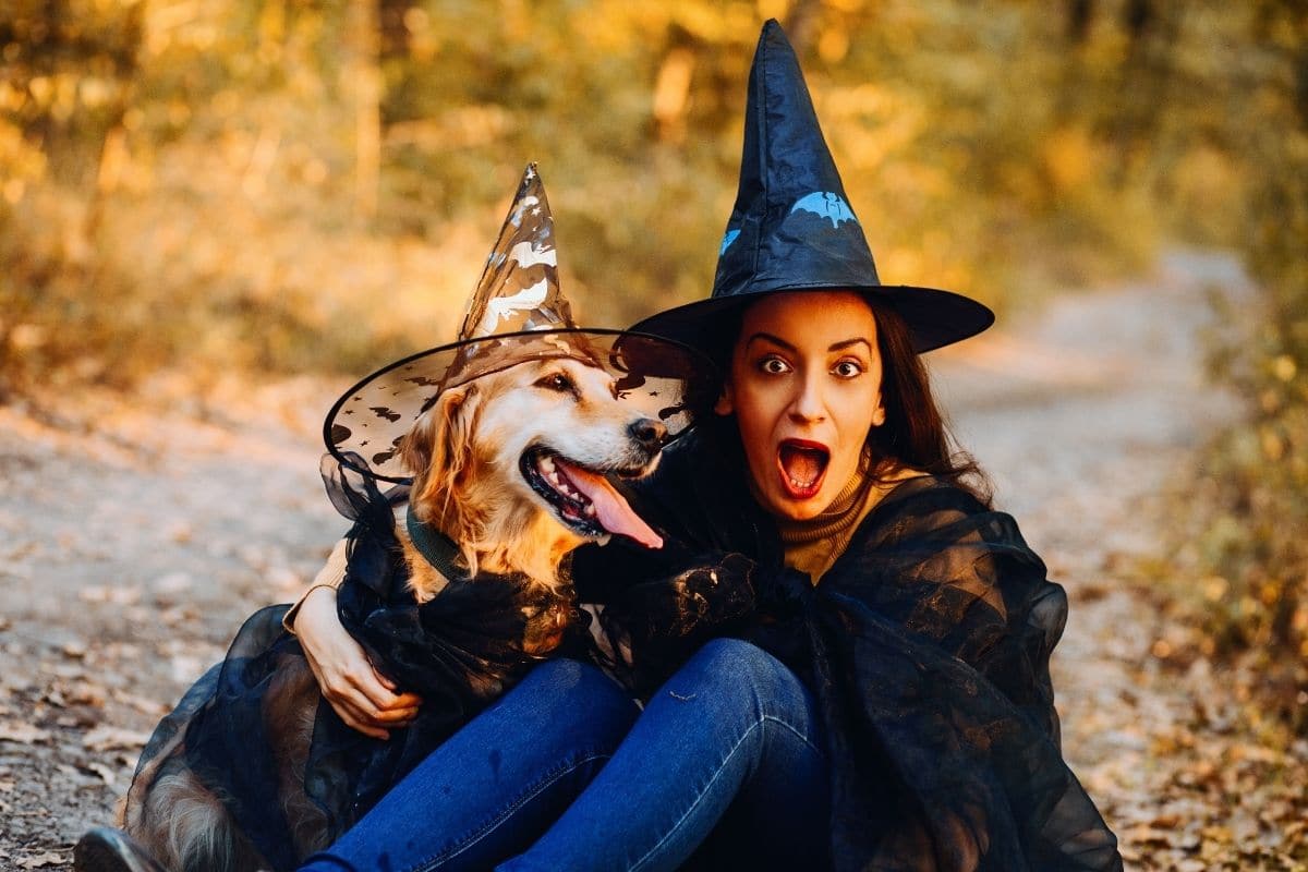 Woman with dog wearing wizzard costumes on road